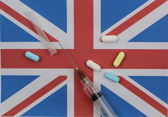 Fototapeta premium English flag with syringe and various drugs. Health and drug trafficking concept