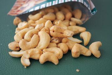 Cashews spilling from a snack bag on a table