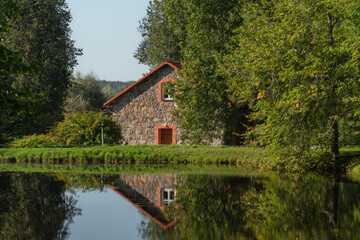 A traditional stone barn for storing flax on the shore of the pond 