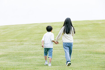 丘の上を歩く子どもの後ろ姿