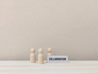 wooden dolls with the word Collaboration. working together concept
