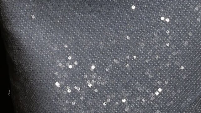 Horizontal video close up. Woman in shiny sea dress with texture of textile with blue bright round sequins, scales, rhinestones that shimmer in light. Concept of disco, fashion, mermaid tail. Glow