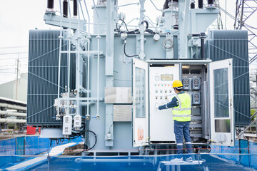 Engineer is working on high voltage power substation performing inspection and check of infrastructure to ensure safety and proper operation of electrical system