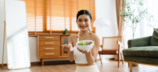 Healthy Asian Woman Enjoying Fresh Salad at Home After Yoga Workout