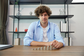 young man counting coins on a table for save money