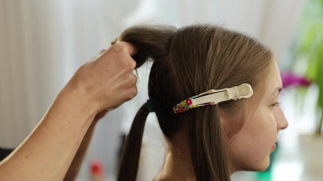 Creative hair styling techniques for a girl in a beauty salon, close-up