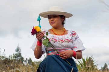 Indigenous ecuadorian woman holding roses in otavalo market