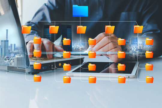 Folder gradation structure and document management system DMS. Businessman using laptop computer for saving and categorization files.Double exposure urban  and edific background.