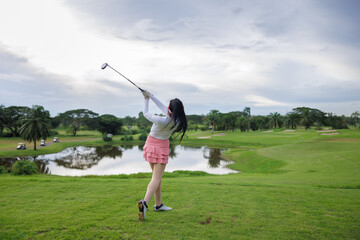 asian women swing and hitting golf ball at the golf course,