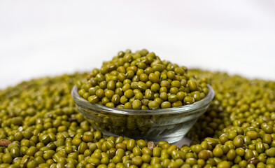 Vertical shot of Green Moong Dal beans in a Glass Bowl Isolated on a white background. The mung...