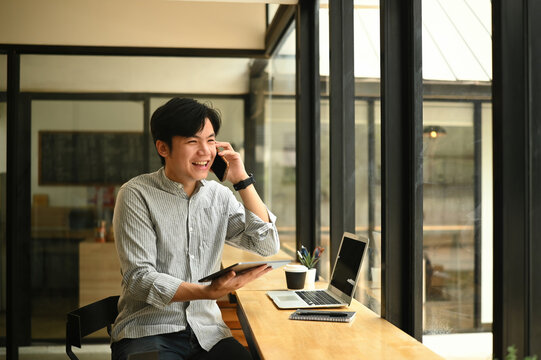 Smiling Freelancer on a Business Call in Cafe Workspace