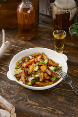 Fried potatoes with onions, rustic bright mood, overhead composition in white ceramic bowl