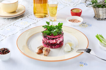 Layered herring under beet salad plated, bright, overhead composition for restaurant menu use