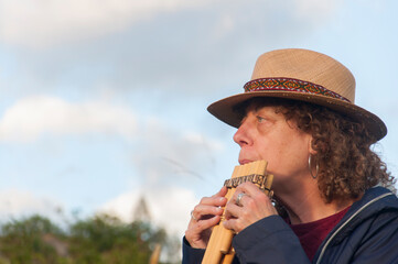 Musician playing andean pan flute outdoors in nature © Martin Stock Studio