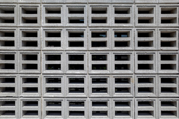 Grey perforated bricks with air gaps by the side of a building