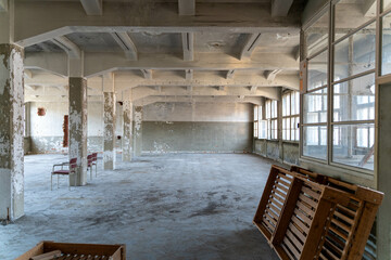 Abandoned industrial hall with old furniture, metal parts, and dusty workspaces. Atmospheric lost...