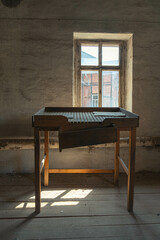 Abandoned industrial hall with old furniture, metal parts, and dusty workspaces. Atmospheric lost...