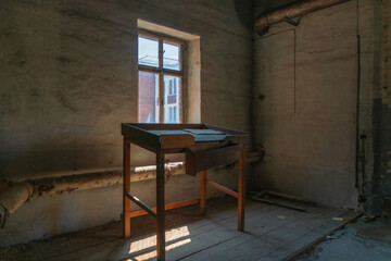 Abandoned industrial hall with old furniture, metal parts, and dusty workspaces. Atmospheric lost...