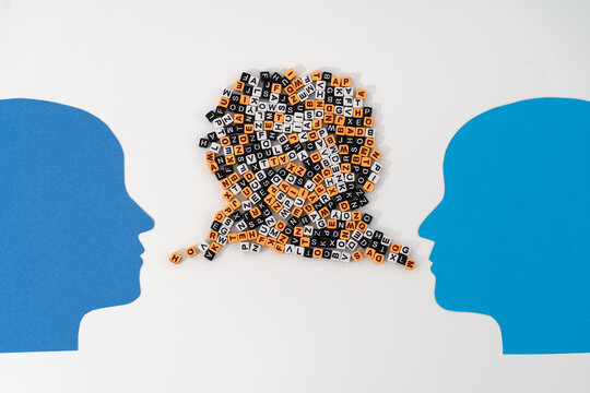 Two paper-cut heads facing each other, with streams of mixed letters flowing from their mouths symbolizing complex communication, shared thoughts, and the exchange of ideas or emotions or quarrel