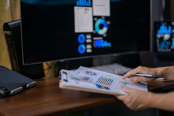 A person is looking at a computer monitor with a lot of graphs and charts on it