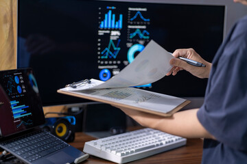 A person is holding a clipboard with a white piece of paper and a pen