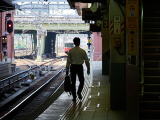 名古屋の金山駅のホームで歩くサラリーマンの姿と駅の風景