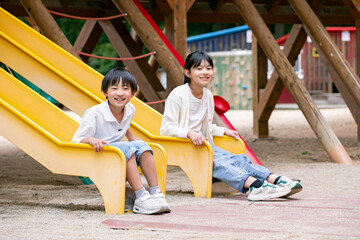 公園の遊具で遊ぶ小学生