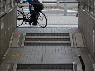 街の駅前の地下駐輪場の入り口と若者の姿