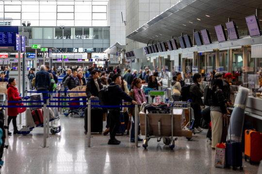 Frankfurt Airport, Germany - February 19, 2024: busy airport check-in counter with travelers and luggage