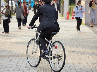 Fototapeta premium 日本の都市の街の通行人と自転車を乗るサラリーマンの姿