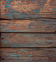 Multiple weathered wooden planks with chipped paint outdoors