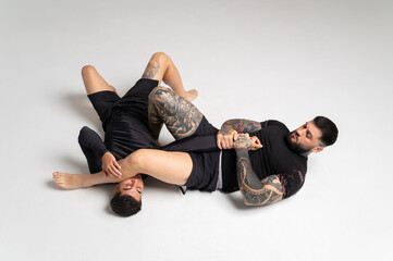 Two mixed martial arts fighters grappling on the floor