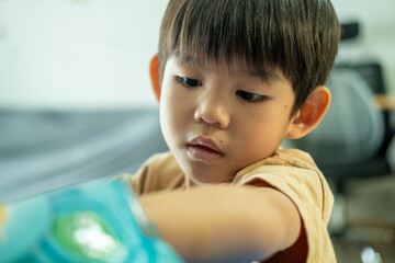 Asian boy reaching for a bag of candy