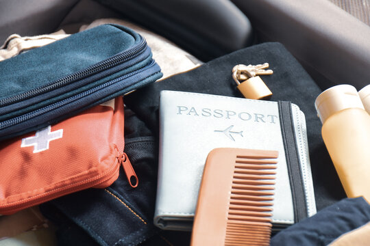 Close-up of travel accessories in a suitcase. Personal items, medication, electronics and passport holder on a carry-on bag. Selective focus.