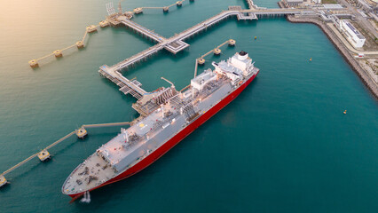 Aerial view of an LNG tanker docked at an offshore terminal with multiple pipelines, storage tanks,...