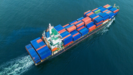 Aerial view of a cargo container ship sailing across the open sea, stacked high with colorful...