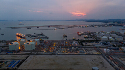 Aerial view of an LNG tanker docked at an offshore terminal with multiple pipelines, storage tanks,...