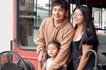 Latin american family exploring vintage red bus during day trip