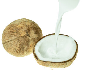 Fresh coconut milk being poured into a halved coconut shell, isolated on white background. Concept of tropical cuisine, plant-based milk, and organic food ingredients.