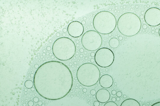 Macro microscope green bubble texture, Close-up Green bubbles and drops oil background . blue green water bubbles, close up golden oil drop for cosmetic - Powered by Adobe