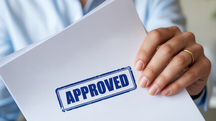Person holding document with Approved stamp, symbolizing success and validation