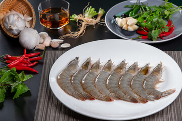 raw freshness shrimps on white dish with black table background preparing for food
