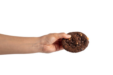 A large chocolate cookie topped with chocolate chips and hand, set against a transparent background.