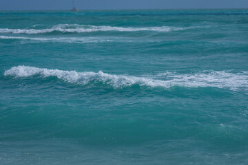 Turquoise sea water wave motion. Summer beach. Calm sea. Beauty sky and waves on beach. Beautiful foamy shoreline. Sea background. Blue ocean. Sandy ocean beach. Sea waves.