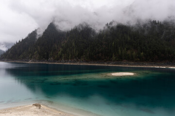 Jiuzhaigou, China: Dramatic view of the long lake on a foggy spring morning in the famous jiuzhaigou scenic area in the mountain of Sichuan in China