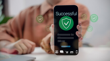 Close-up hand holding smartphone showing successful online payment with security check icon. Concept of mobile banking, digital transaction, fintech, and secure online financial technology.