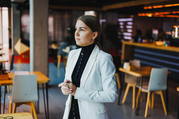 A confident businesswoman excels in a modern office, showcasing professionalism and strong leadership. Her stylish presence fosters productivity, collaboration, and inspiration among her peers