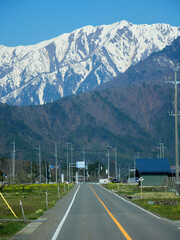 春の観光名所長野県の大町の農家と立山連峰の雪景色
