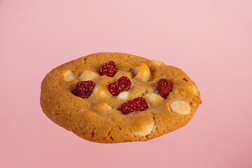 Vanilla cookies topped with nuts and strawberries on a pink background