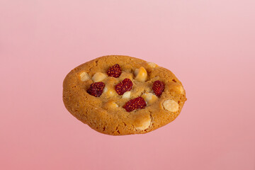 Vanilla cookies topped with nuts and strawberries on a pink background